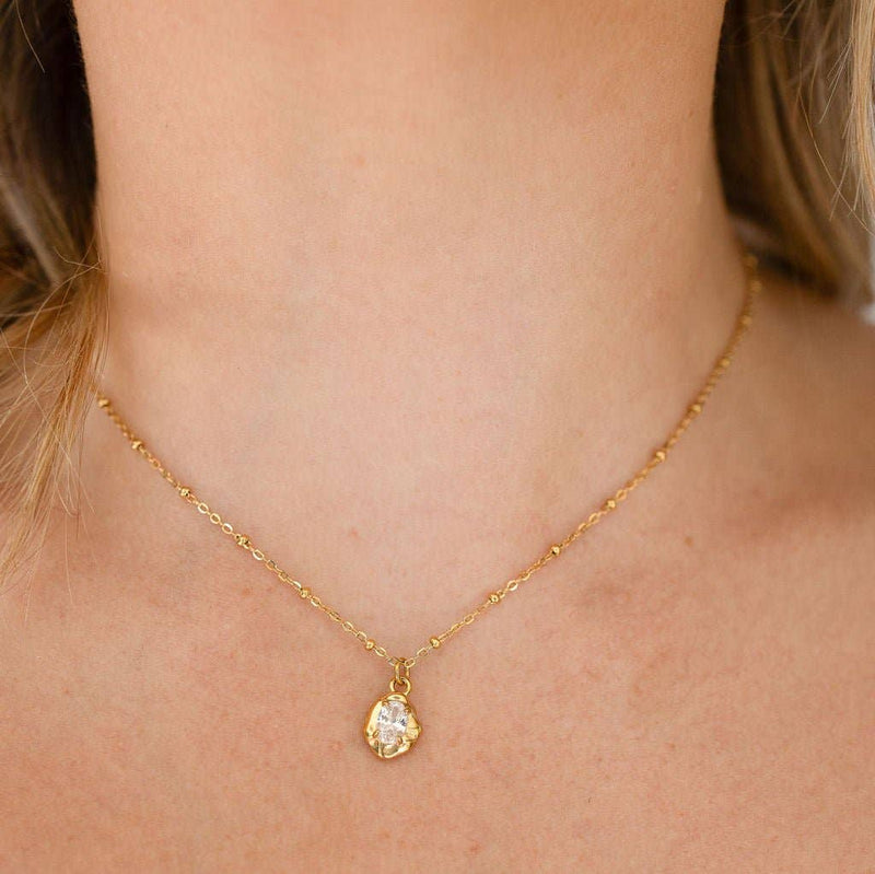Gold necklace with a pendant on a woman's neck
