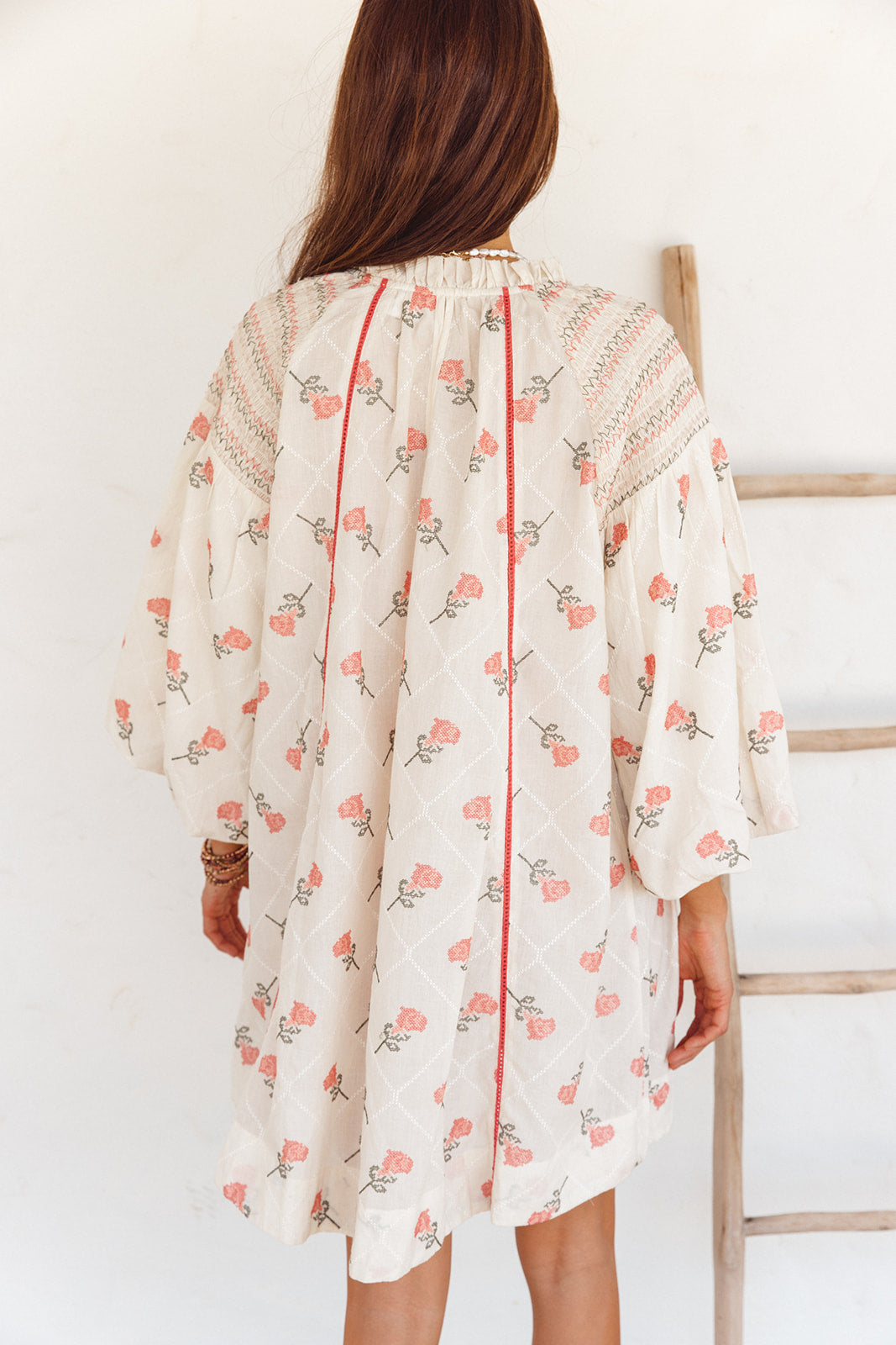 Woman wearing a floral dress against a white background