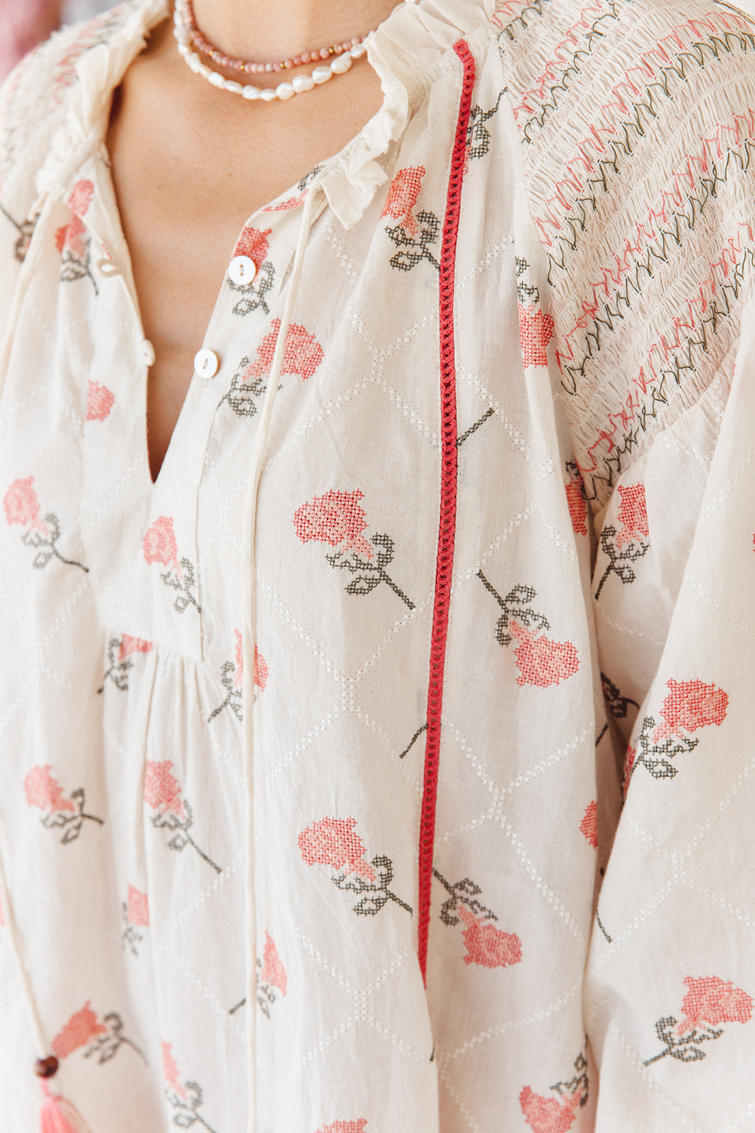 Floral-patterned garment with a red trim detail on a white background