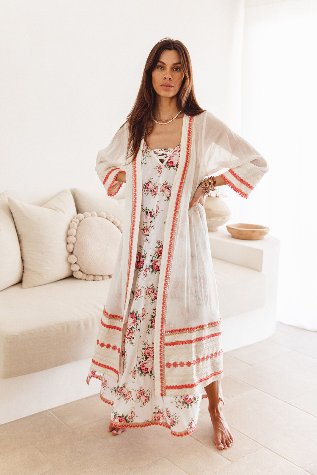 Woman wearing a floral dress with a matching cover-up in a bright room.