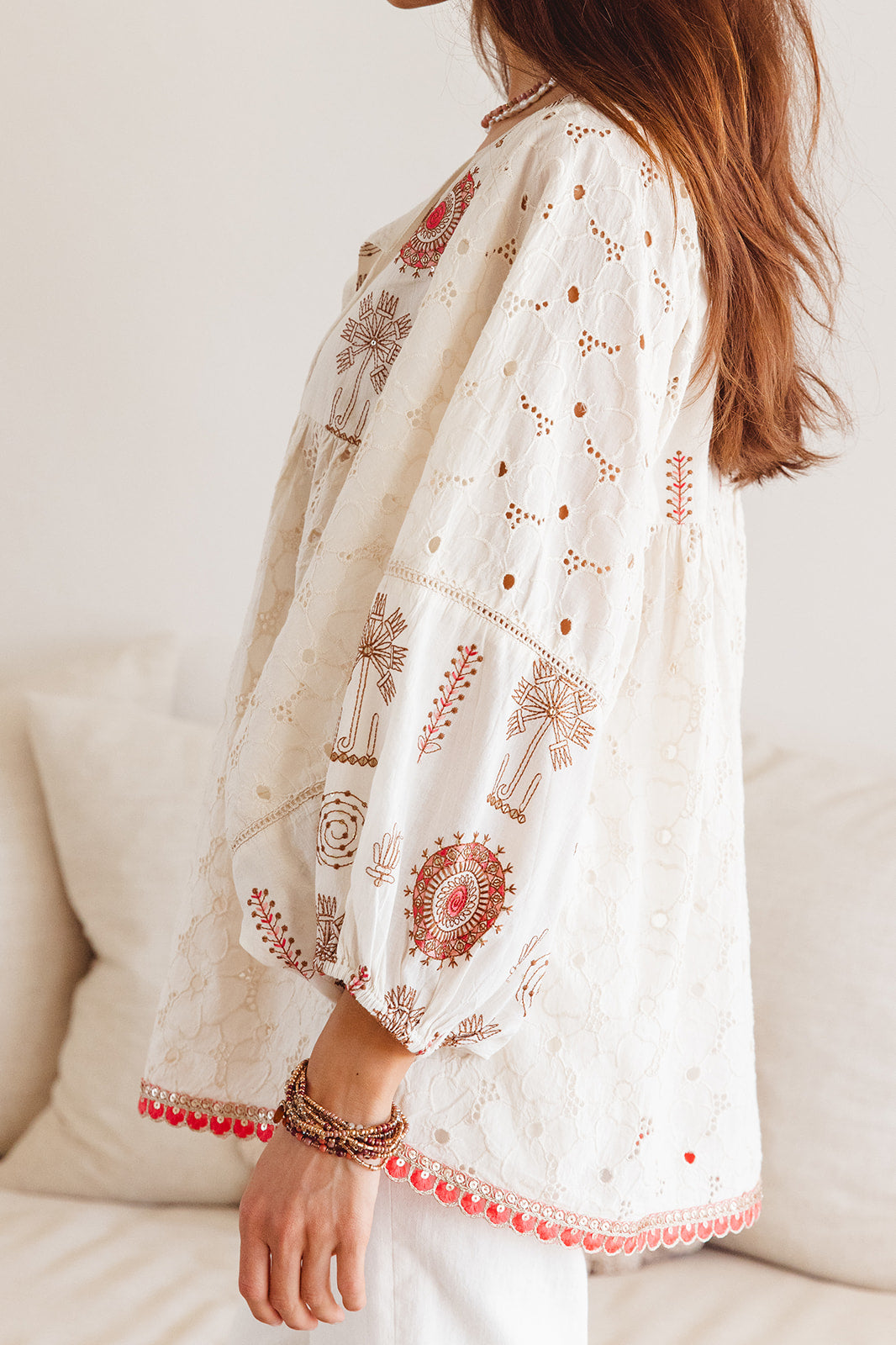 Woman in embroidered long blouse with red detail