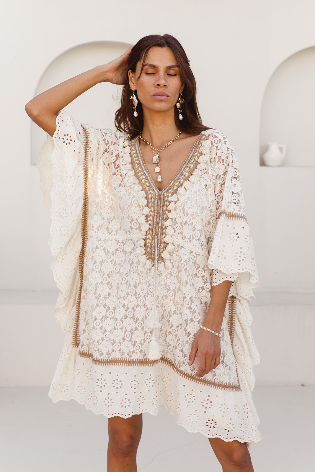 Woman wearing a white lace dress against a white background