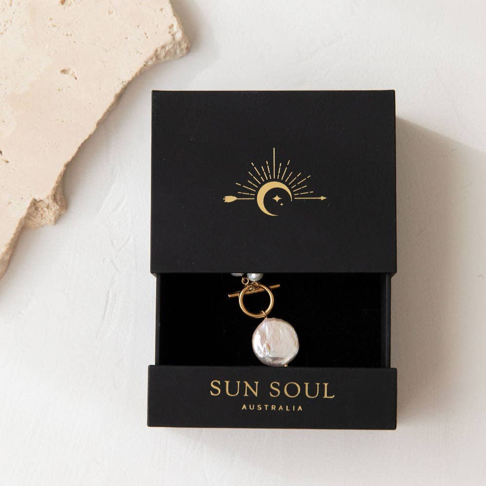 Jewelry box with a pendant labeled 'Sun Soul Australia' on a light background