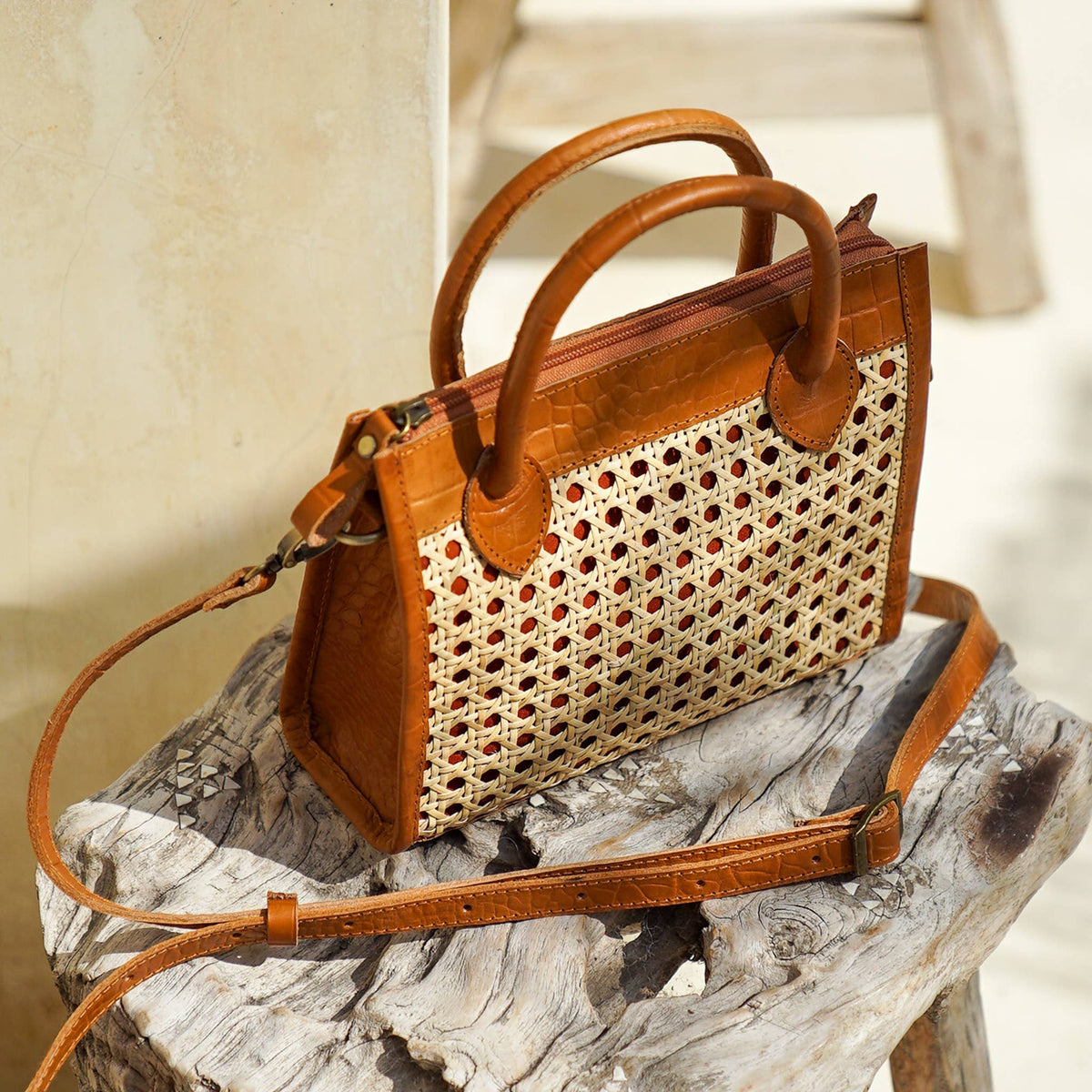 Brown handbag with woven pattern on a wooden surface